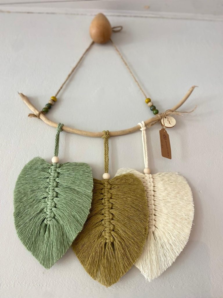 Suspension murale avec trois feuilles en macramé, teintées en vert et crème.