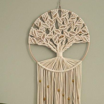 Suspension en macramé représentant un arbre de vie aux branches détaillées et aux feuilles décoratives.